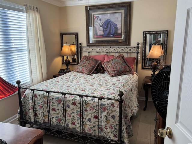 bedroom with wood finished floors, baseboards, and ornamental molding