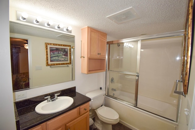 full bath with vanity, visible vents, shower / bath combination with glass door, a textured ceiling, and toilet