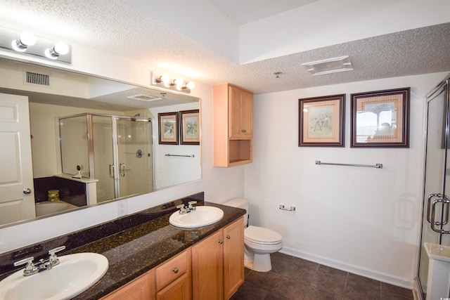 full bathroom with a textured ceiling, a shower stall, visible vents, and a sink