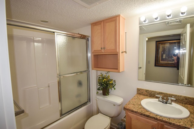 full bathroom with visible vents, toilet, a textured ceiling, bath / shower combo with glass door, and vanity