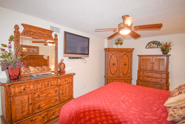 bedroom featuring visible vents, a textured ceiling, and ceiling fan