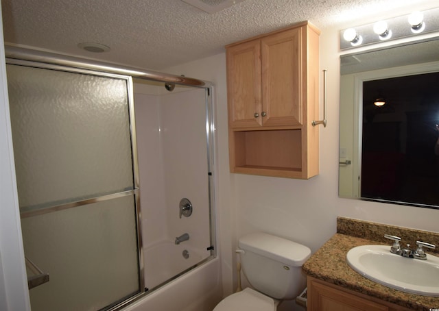 bathroom featuring vanity, toilet, bath / shower combo with glass door, and a textured ceiling