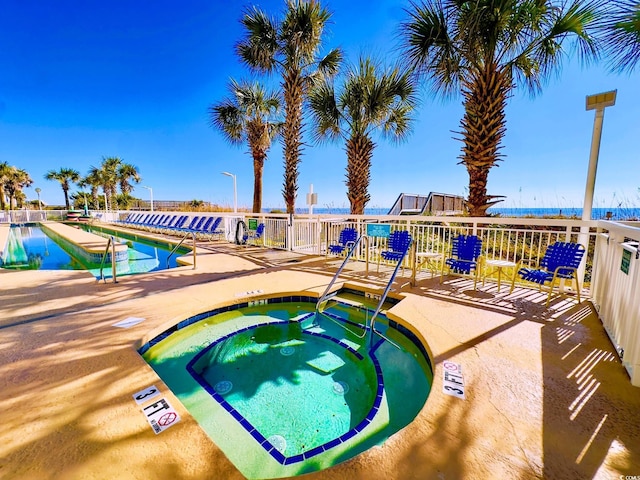 community pool with a patio area and a community hot tub