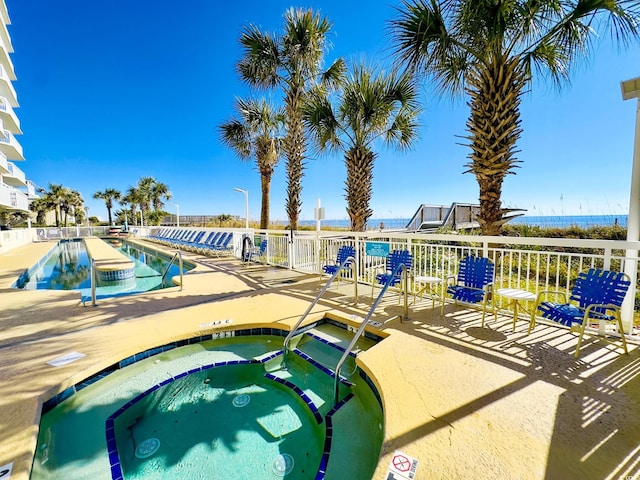 community pool featuring a patio area and a hot tub