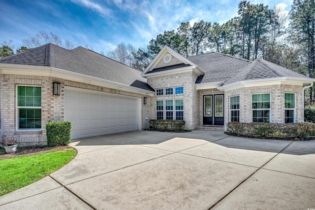 view of front of house featuring a garage, driveway, brick siding, and roof with shingles