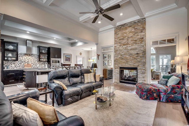 living area featuring ornamental molding, beam ceiling, and wood finished floors