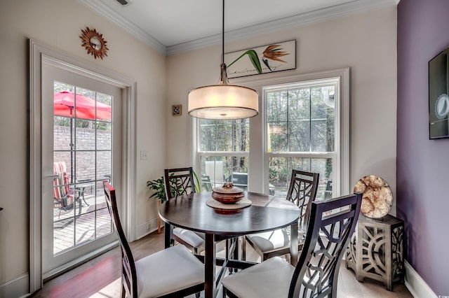 dining space with light wood-type flooring, baseboards, and ornamental molding