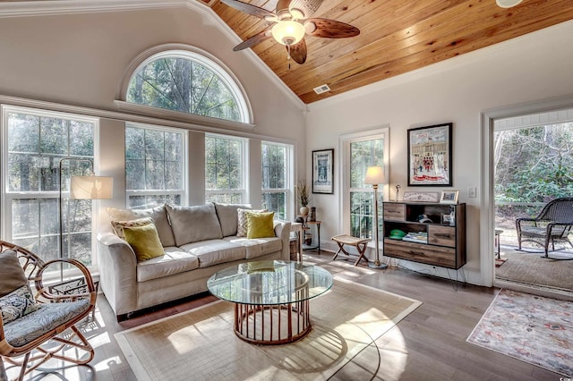 living area featuring a healthy amount of sunlight, wood ceiling, high vaulted ceiling, and wood finished floors