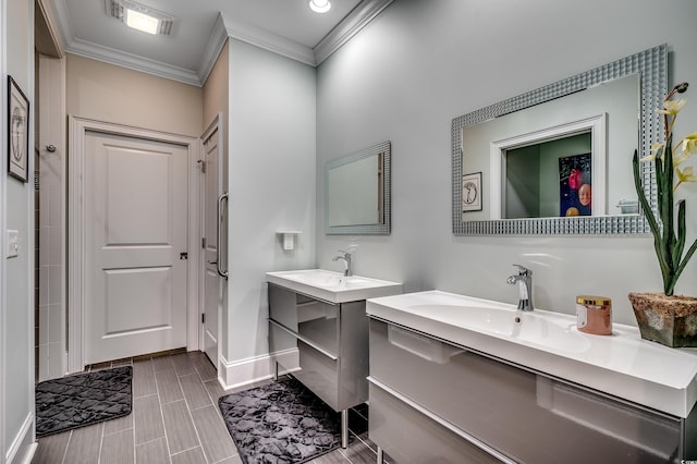 bathroom featuring baseboards, visible vents, two vanities, crown molding, and a sink