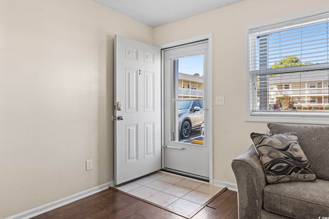 doorway to outside featuring light wood-style flooring and baseboards