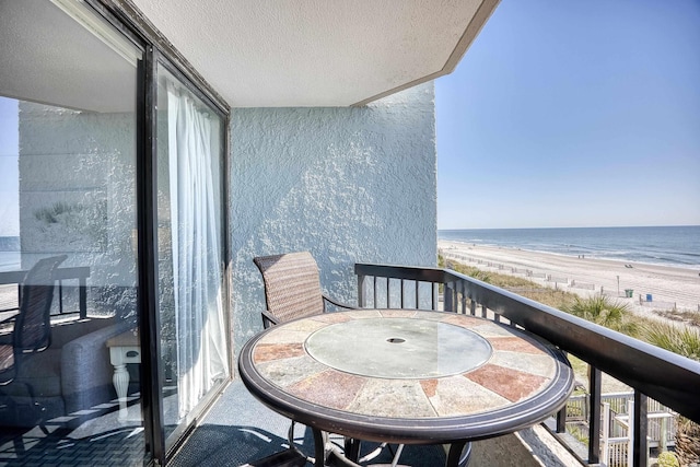 balcony featuring a water view and a view of the beach