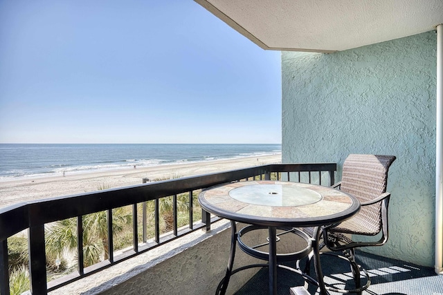 balcony with a water view and a beach view