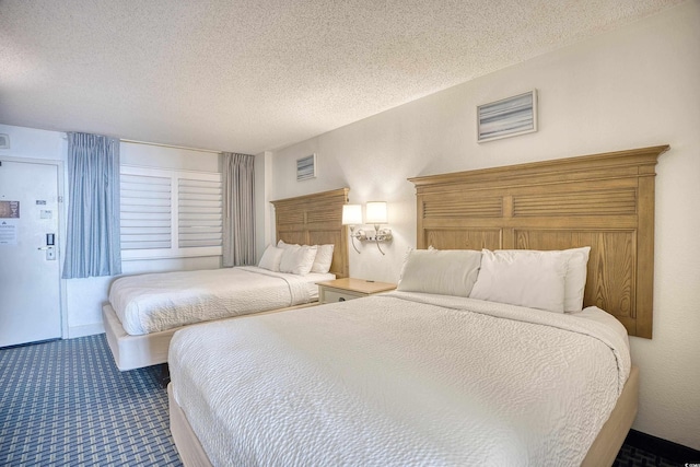 carpeted bedroom featuring visible vents and a textured ceiling