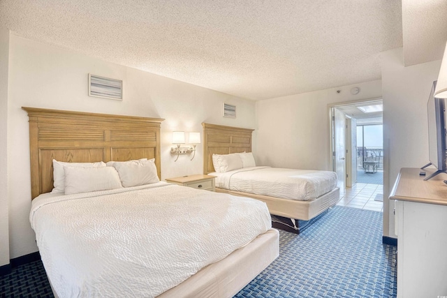 bedroom with a textured ceiling, visible vents, and light colored carpet