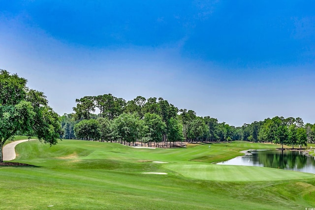 view of home's community with view of golf course, a water view, and a lawn