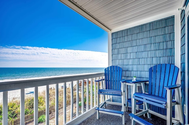 balcony featuring a beach view and a water view