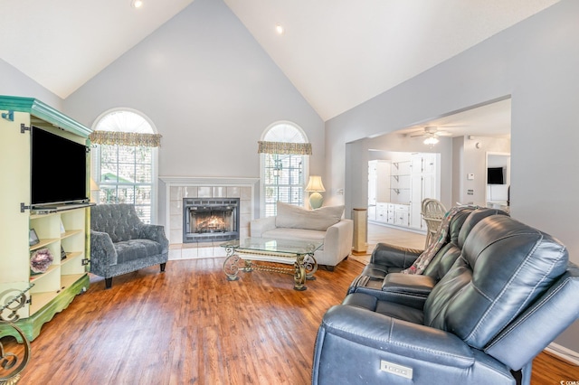 living room with a tile fireplace, a healthy amount of sunlight, and wood finished floors