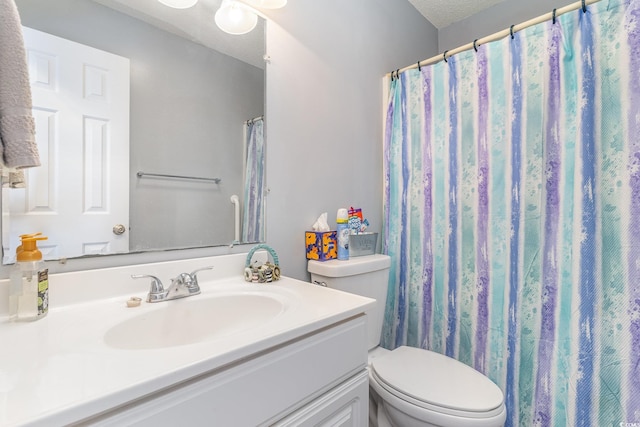 full bathroom with a textured ceiling, vanity, and toilet