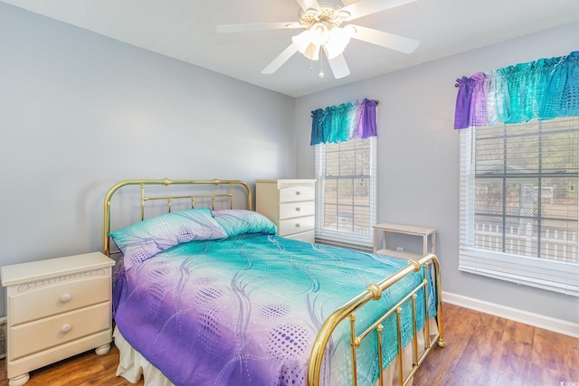 bedroom featuring baseboards, a ceiling fan, and wood finished floors