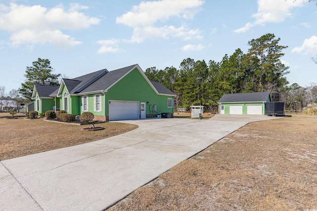 view of front of property featuring a detached garage and an outbuilding