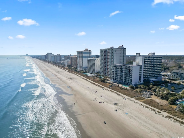 birds eye view of property with a water view, a view of the beach, and a city view