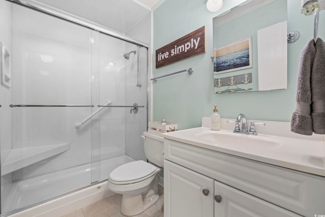 bathroom featuring a stall shower, vanity, toilet, and tile patterned floors