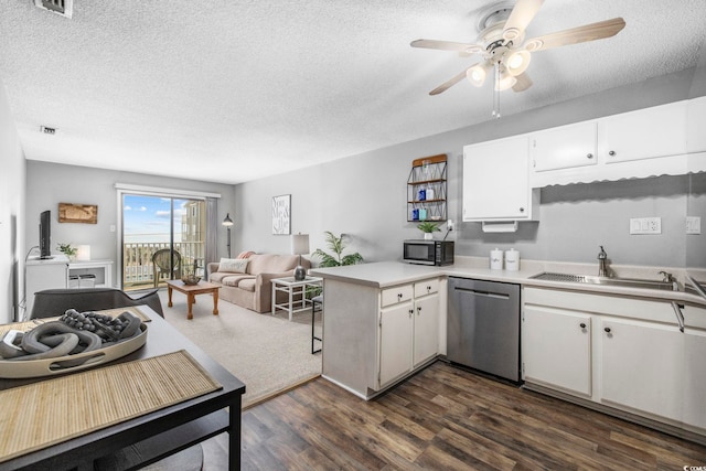 kitchen featuring light countertops, white cabinets, a sink, dishwasher, and a peninsula