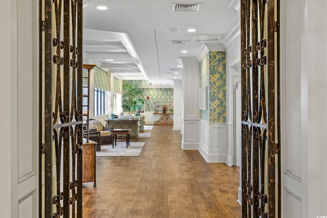 foyer with wallpapered walls, visible vents, a decorative wall, and a wainscoted wall