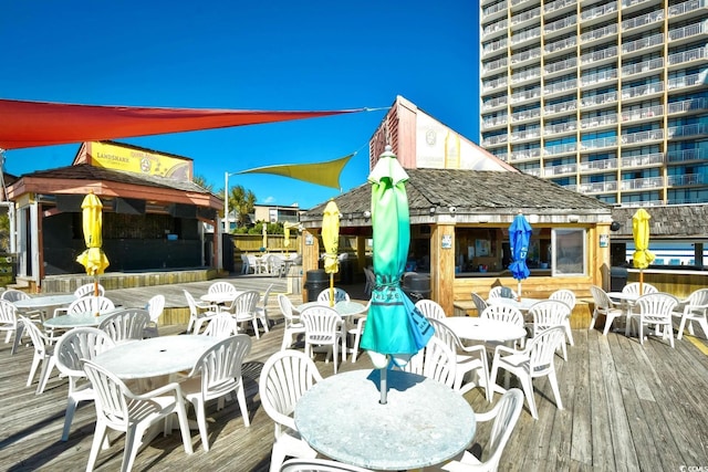 wooden terrace with a gazebo and outdoor dining area