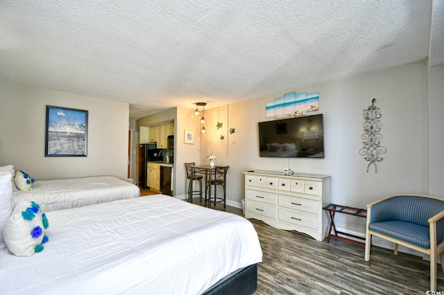 bedroom with a textured ceiling, dark wood finished floors, and baseboards