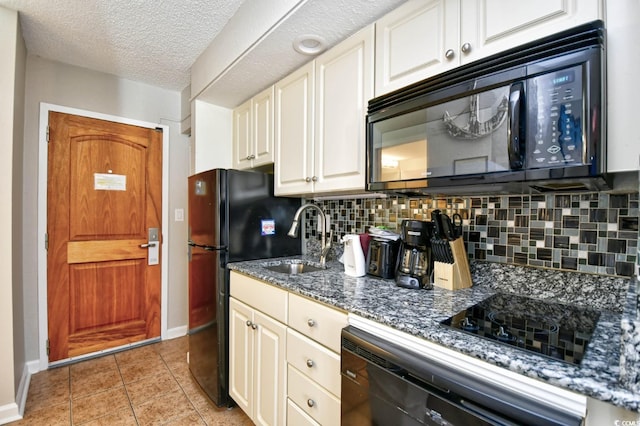 kitchen with light tile patterned floors, tasteful backsplash, a sink, a textured ceiling, and black appliances