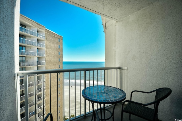 balcony featuring a water view and a view of the beach