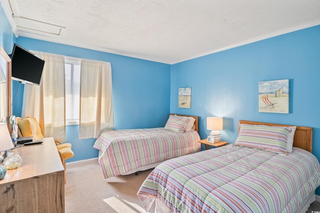 carpeted bedroom featuring baseboards, attic access, ornamental molding, and a textured ceiling