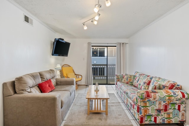 living area featuring a textured ceiling, ornamental molding, light tile patterned flooring, and visible vents