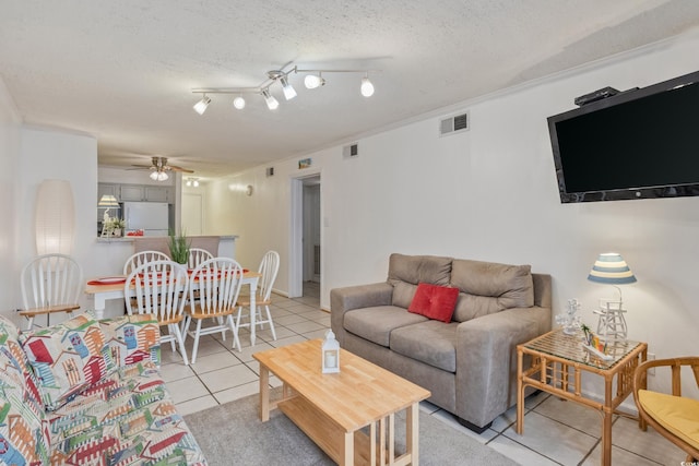 living room featuring visible vents, ceiling fan, a textured ceiling, and tile patterned floors