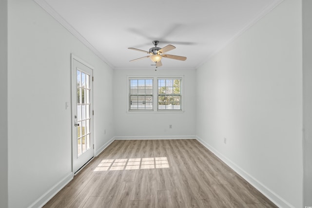 spare room featuring baseboards, ceiling fan, crown molding, and light wood finished floors