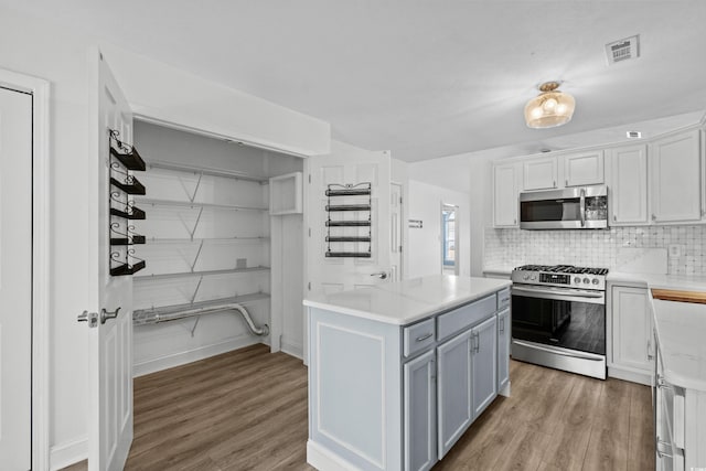 kitchen featuring decorative backsplash, appliances with stainless steel finishes, light wood-type flooring, and light countertops