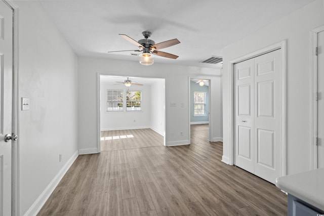 interior space featuring visible vents, a healthy amount of sunlight, baseboards, and wood finished floors