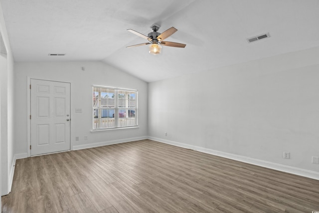 unfurnished living room with visible vents, lofted ceiling, wood finished floors, and a ceiling fan