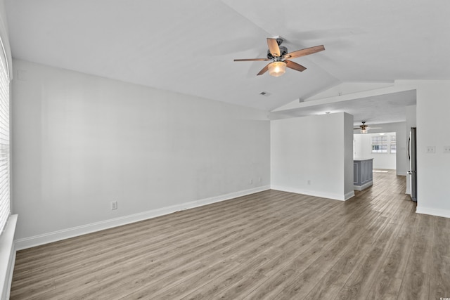 unfurnished living room featuring baseboards, a ceiling fan, lofted ceiling, and wood finished floors