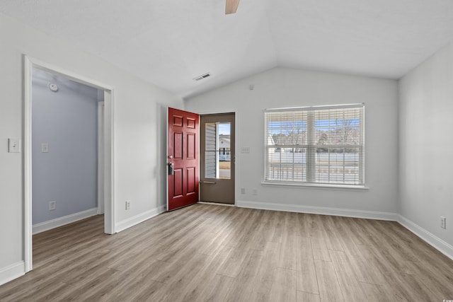 unfurnished room featuring visible vents, baseboards, wood finished floors, and vaulted ceiling