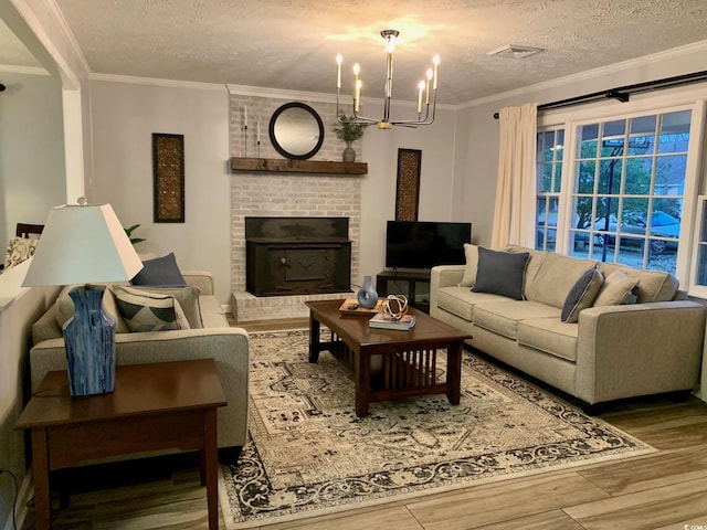 living area with a textured ceiling, ornamental molding, wood finished floors, and visible vents