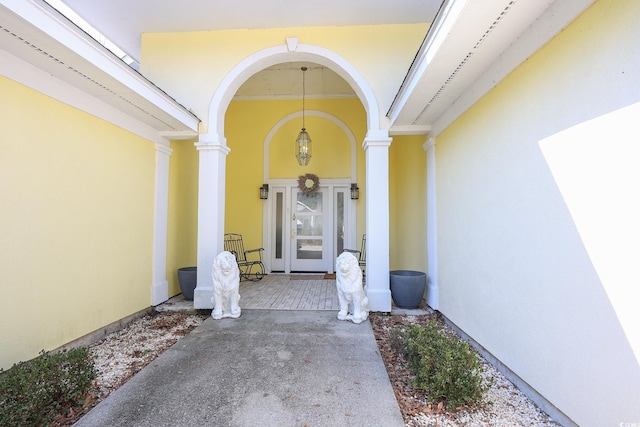 doorway to property with a porch and stucco siding