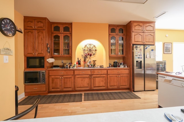 kitchen with black microwave, white dishwasher, built in microwave, stainless steel fridge with ice dispenser, and brown cabinets