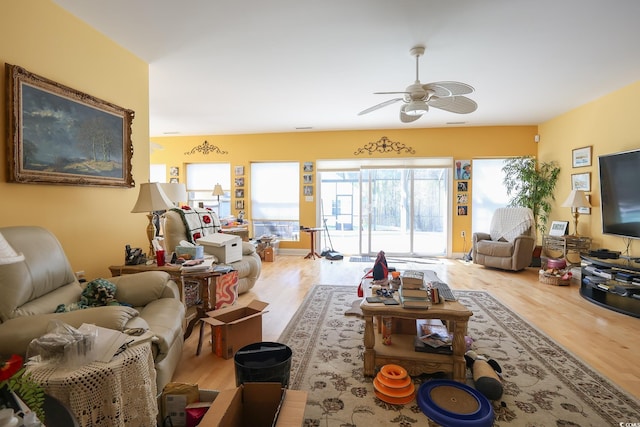 living area with wood finished floors and a ceiling fan