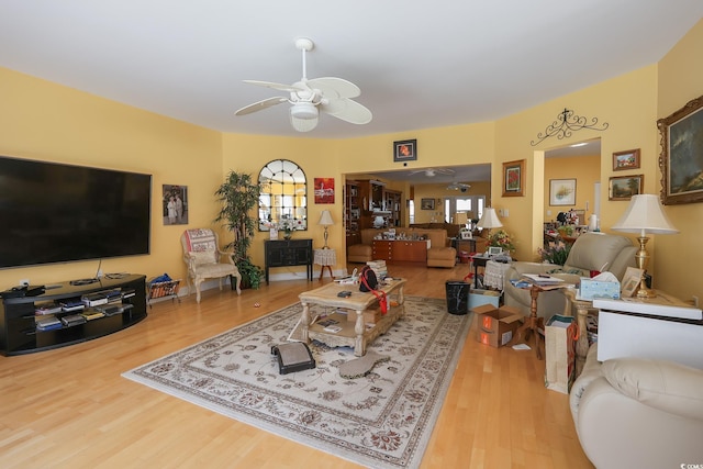 living room with ceiling fan, wood finished floors, and a wealth of natural light