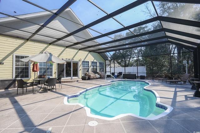 view of pool with glass enclosure, fence, a fenced in pool, and a patio