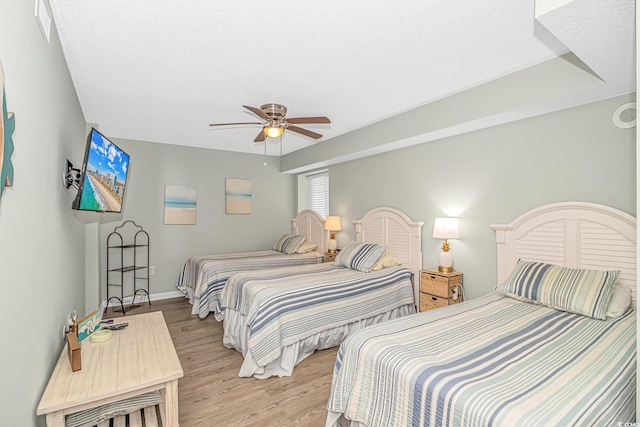 bedroom featuring light wood-style flooring, ceiling fan, and baseboards