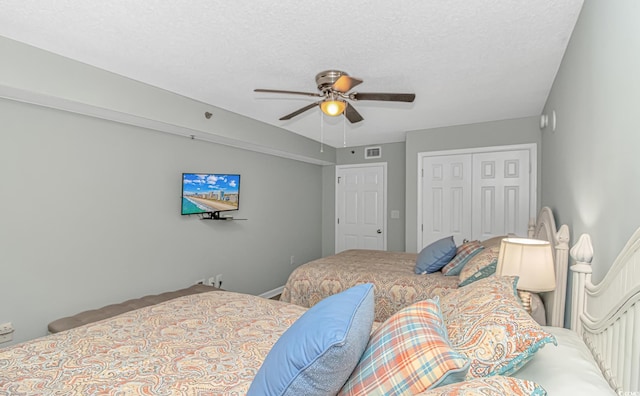 carpeted bedroom with a closet, visible vents, and a ceiling fan