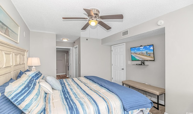 bedroom with ceiling fan, a textured ceiling, baseboards, and visible vents